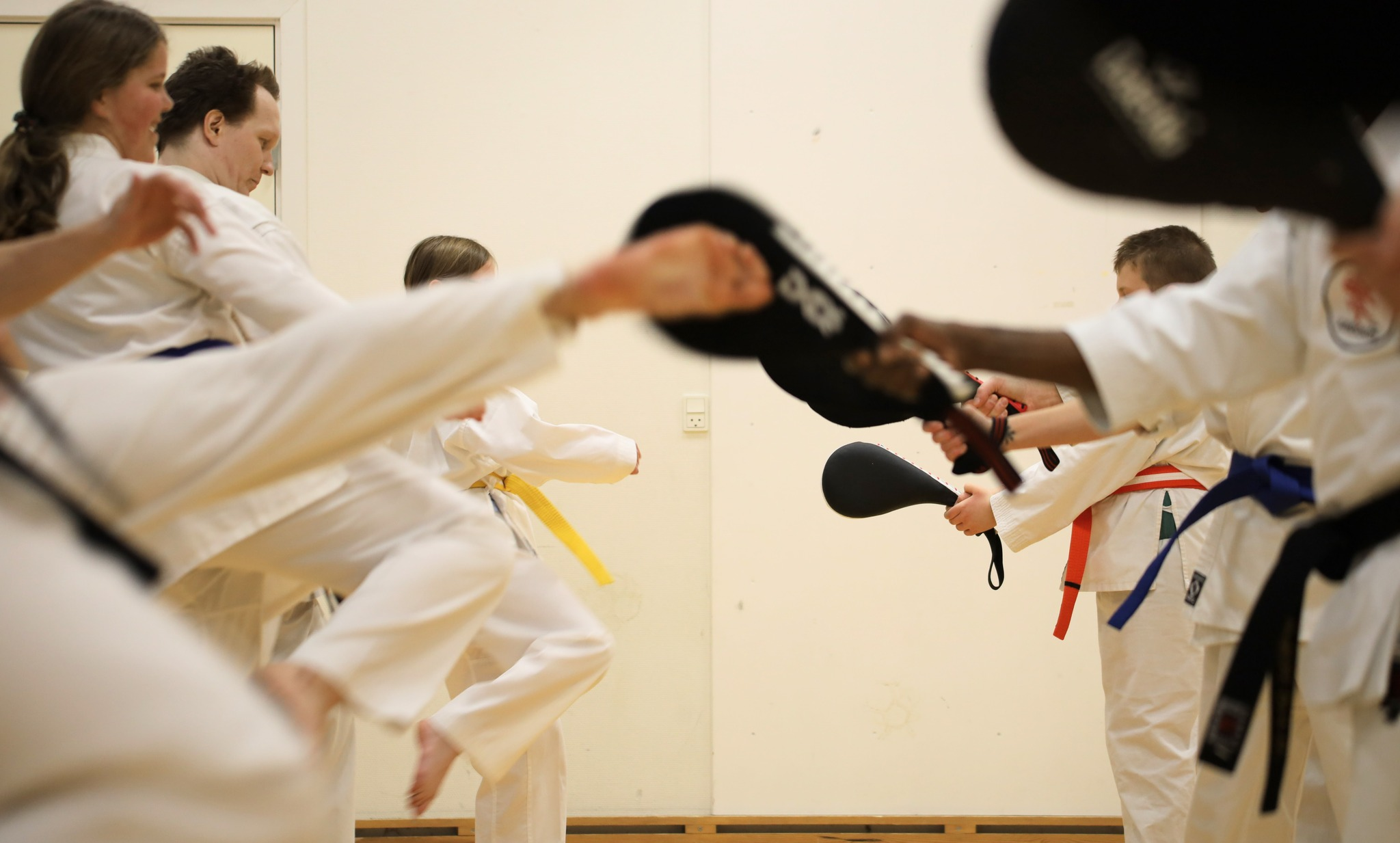 Karateudøvere træner spark på puder i Skovbo Karate Klub